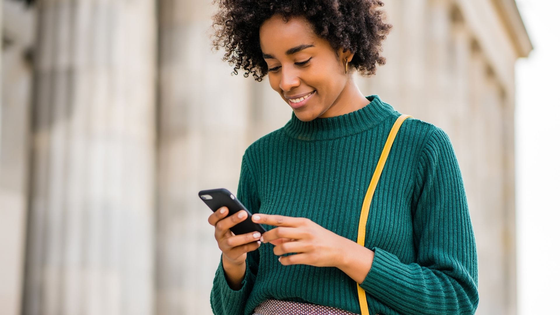 girl in green top looking at phone